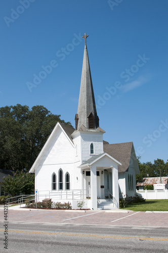 Very small rural christian church with a steeple photo