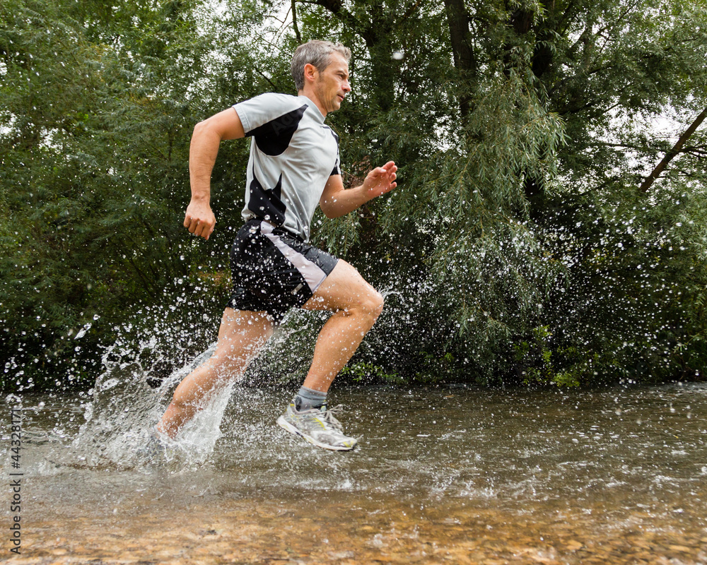 Jogger durchquert ein Bachbett Jogger durchquert ein Bachbett