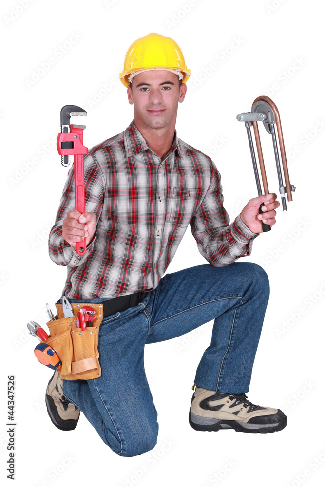 portrait of a plumber with tools in both hands portrait of a plumber with tools in both hands