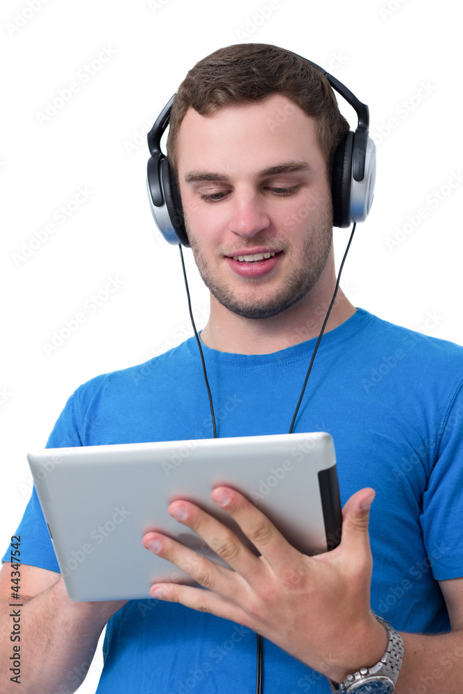 Young man with headphones working on a tablet pc Young man with headphones working on a tablet pc