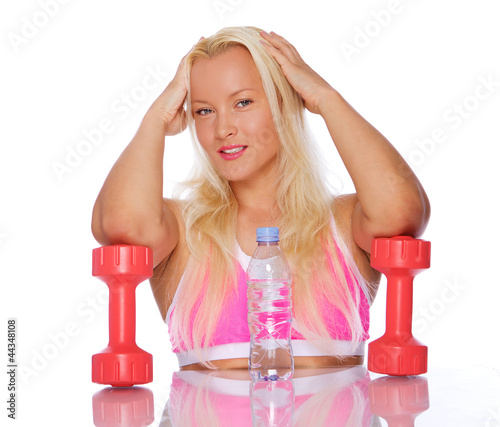 Portrait of sexy woman posing in studio with dumbbells