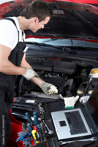 Auto mechanic checking oil.