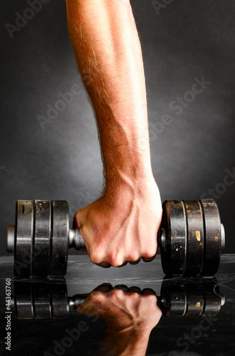 male hand is holding metal barbell