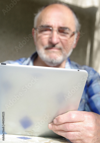 homme senior se servant d'une tablette