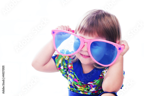 3 years old funny girl wearing colorful glasses isolated over wh