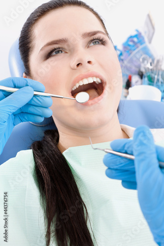 Dentist examines the mouth of the patient on the dentist s chair