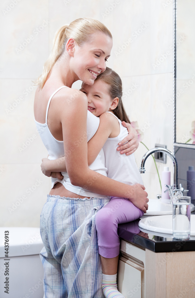 Mother and daughter embrace each other in bathroom Mother and daughter embrace each other in bathroom