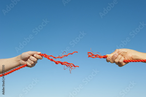 Hands broken rope sky background