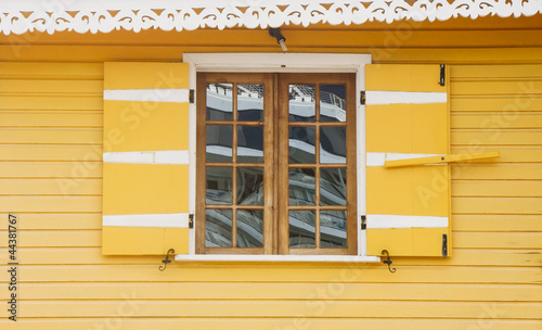 Old Wood Window in Bright Yellow Wall