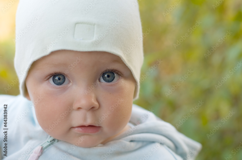 Милый малыш на прогулке в саду