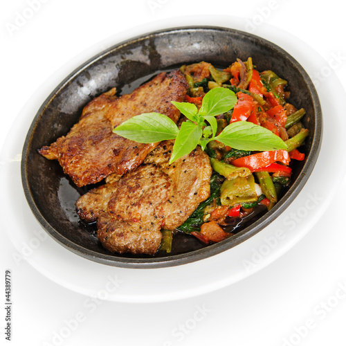 pork steak with vegetables, fried in a pan
