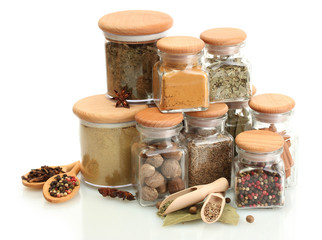 Fototapete Gewürze jars and wooden spoons with spices isolated on white  © Africa Studio