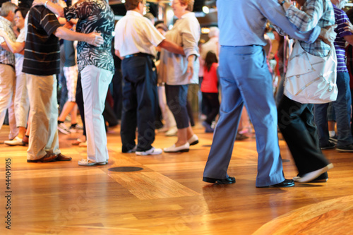Many happy senior couples in love dancing on wooden dance floor. photo