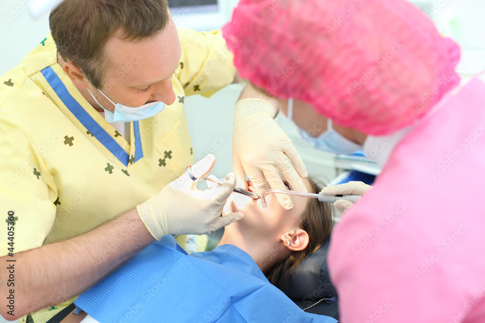 Obraz premium Dentist makes injection to girl sitting in chair