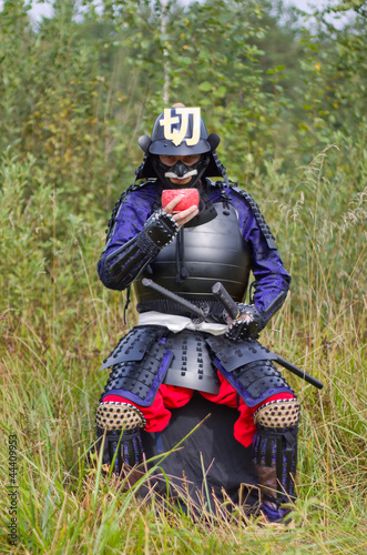 Samurai in armor drinking from bowl