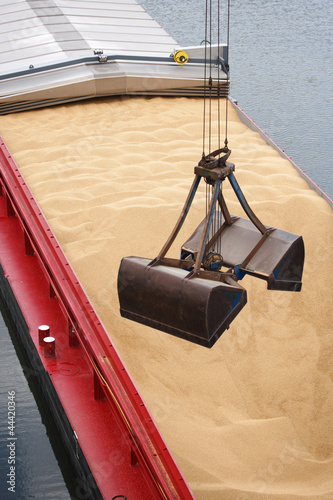 Entladen Sand von Binnenschiff mit Kran