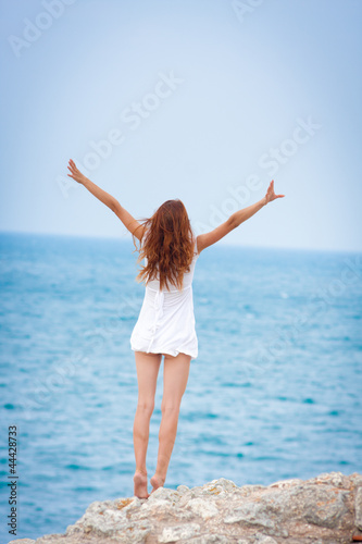 pretty girl standing and looking to a sea