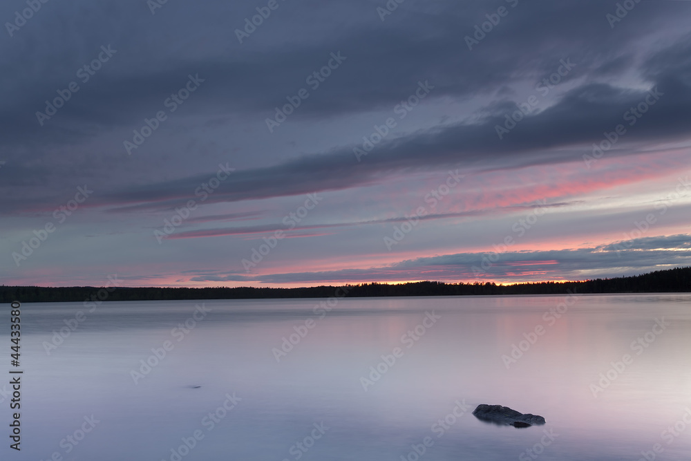 A calm lake, the clouds are reflecting on the surface