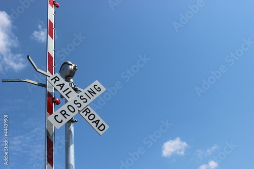 Railroad sign against bright blue skies