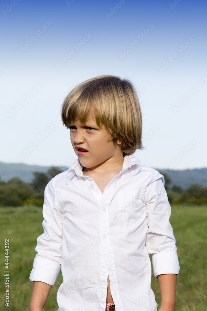 Portrait of young boy outdoors, on sunny summer afternoon
