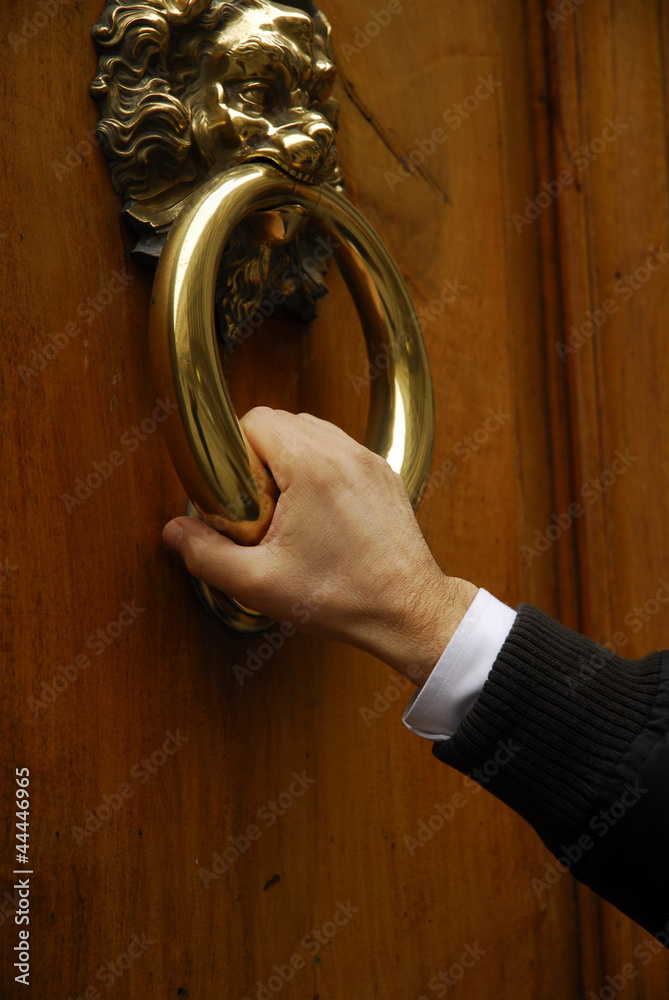 Mano tocando una puerta,sujetando manilla de puerta. foto de Stock | Adobe  Stock