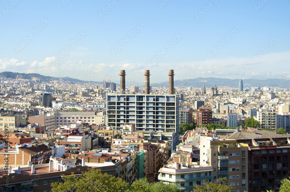 Blick auf ein Bürogebäude und Schornsteine einer alten Kraftwerksanlage im Distrikt El Poble-sec in Barcelona