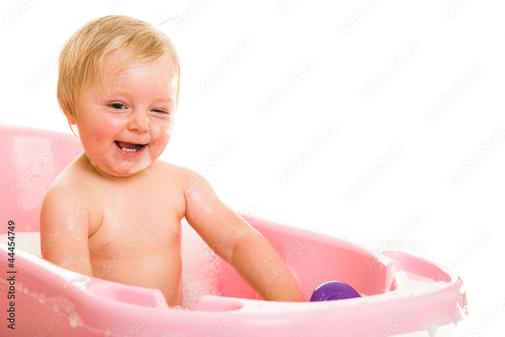 Cute infant girl in bath isolated on white