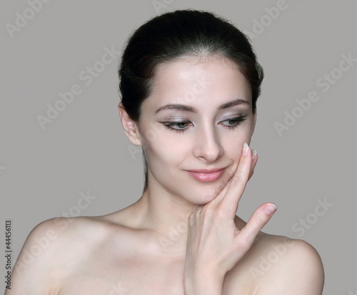 Beautiful woman portrait with hand at clean face looking at isol