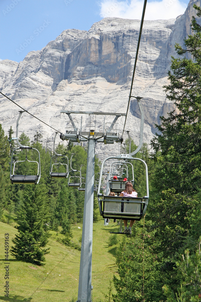 Chair lift people up towards the top of the Dolomites