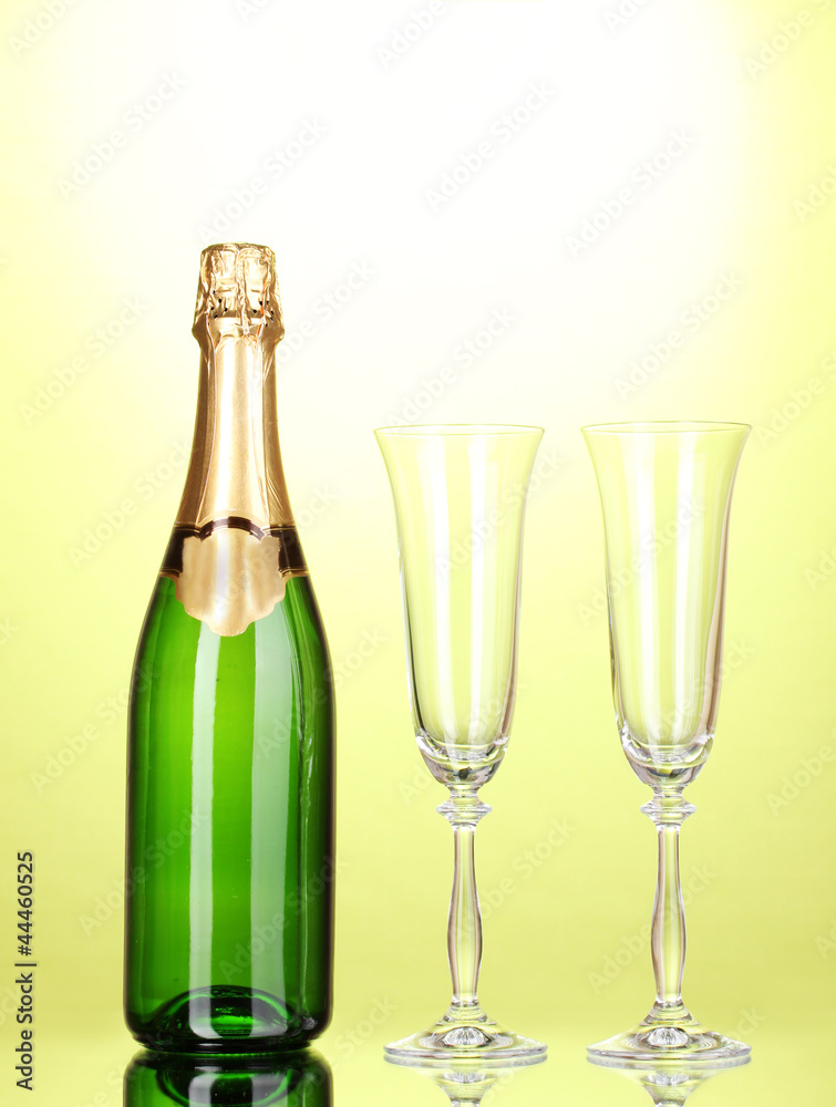 Bottle of champagne and goblets on green background Bottle of champagne and goblets on green background