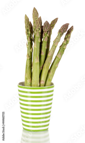 Fresh asparagus in colorful pot isolated on white.