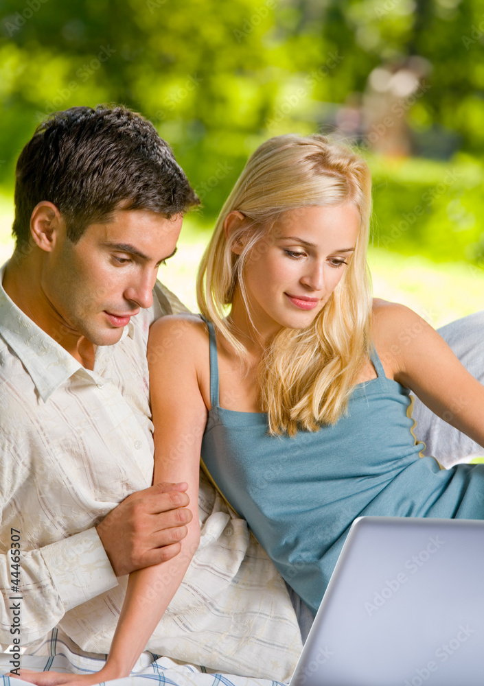Young couple working with laptop, outdoor Young couple working with laptop, outdoor