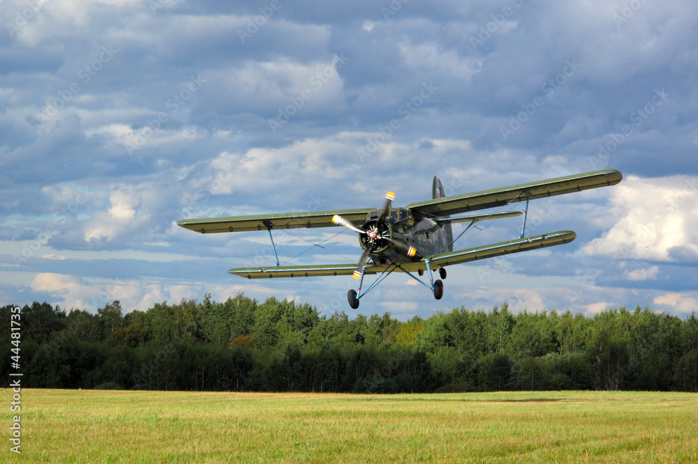 Historic airborne biplane landing at airfield. Historic airborne biplane landing at airfield.