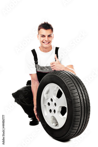 Auto mechanic holding car wheel