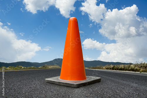 traffic cone on a road with a bright blue sky