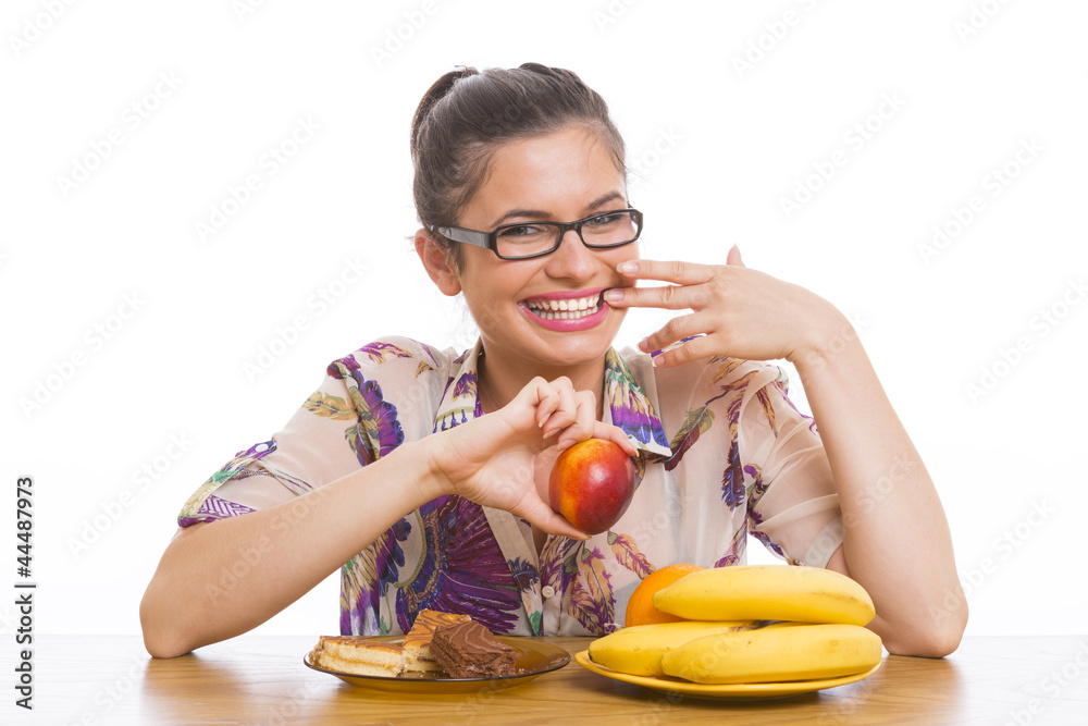 Young laughing woman with fruits and cakes. Dieting concept. Young laughing woman with fruits and cakes. Dieting concept.