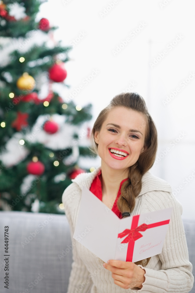 Smiling young woman with Christmas postcard Smiling young woman with Christmas postcard