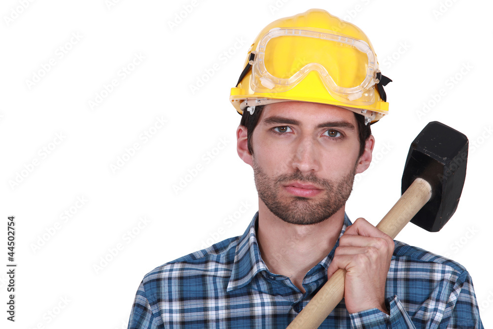 Attractive construction worker with a sledgehammer