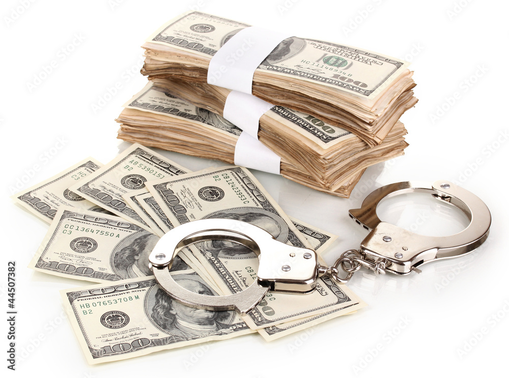 Handcuffs and packs of dollars isolated on white Handcuffs and packs of dollars isolated on white