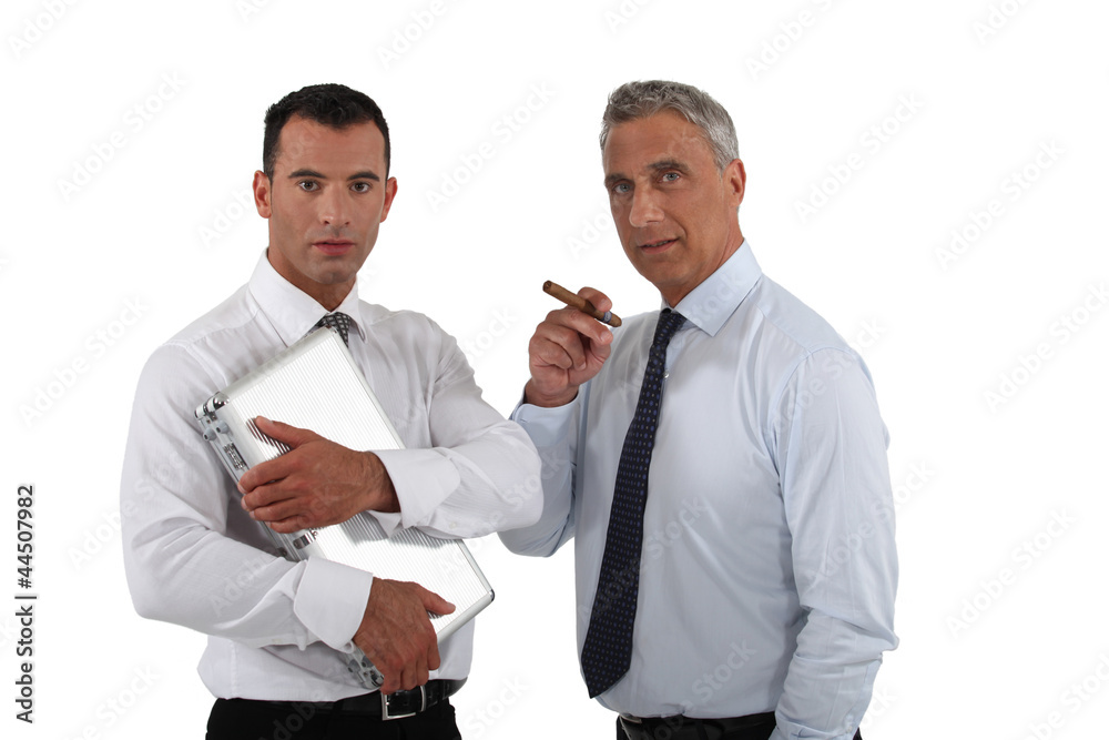 Boss holding cigar whilst employee does all the work Boss holding cigar whilst employee does all the work