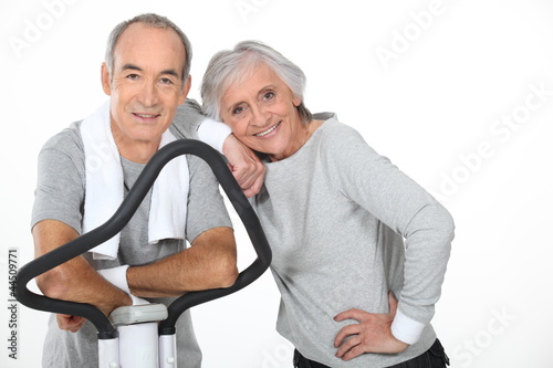 Senior couple using gym equipment