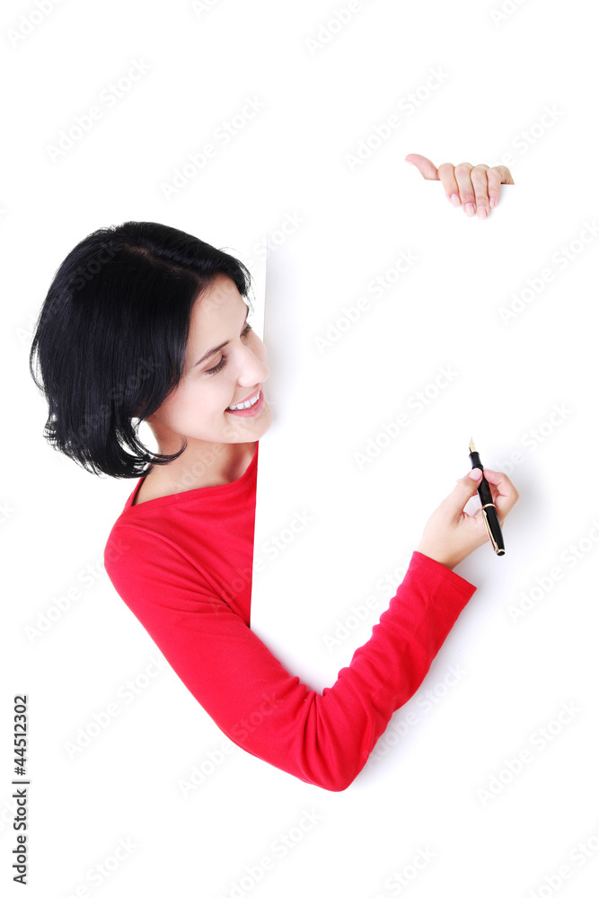 Naklejka premium Happy beautiful woman writing with a pen on blank board.
