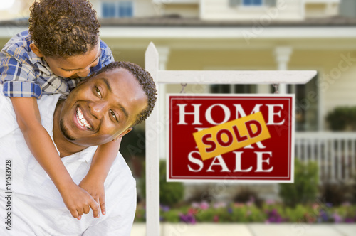 Mixed Race Father and Son In Front of Real Estate Sign and House