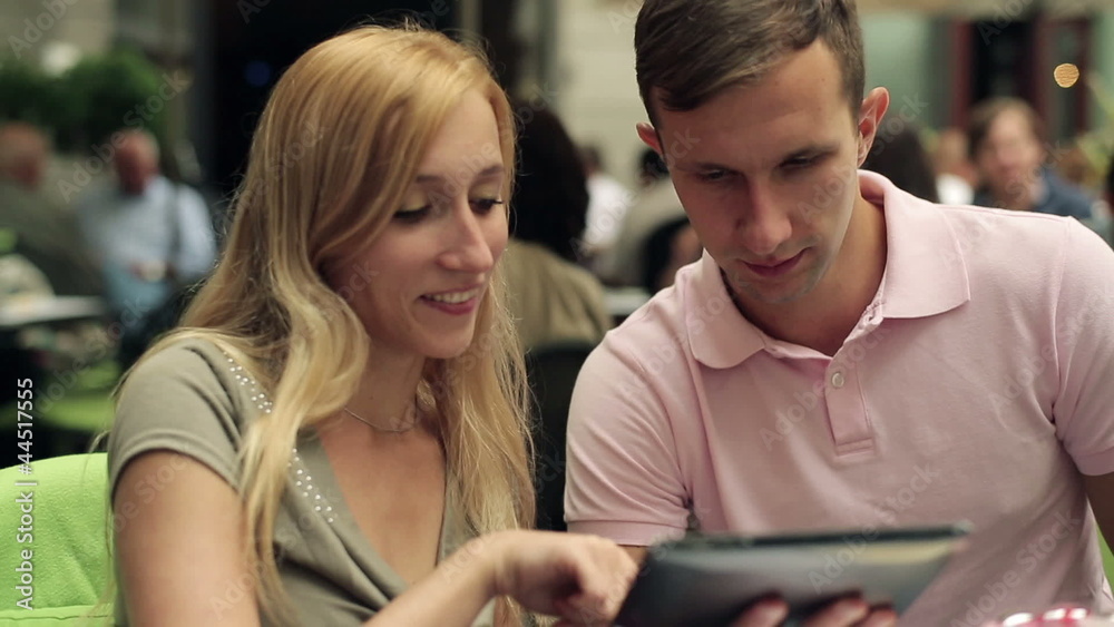 Young happy couple with tablet computer in cafe, steadicam shot Young happy couple with tablet computer in cafe, steadicam shot