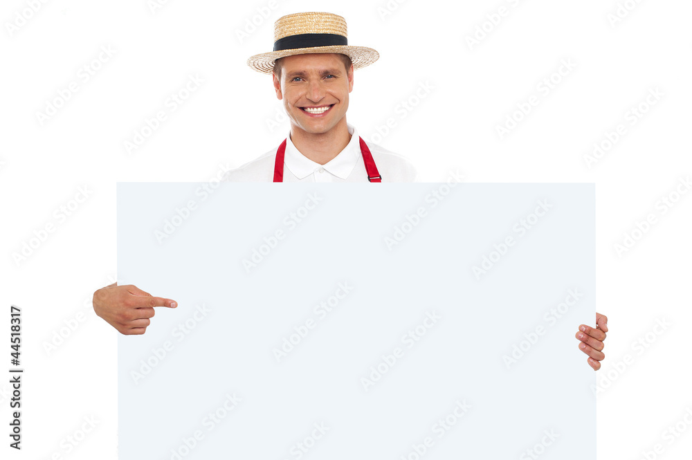 Portrait of cheerful chef pointing at placard Portrait of cheerful chef pointing at placard