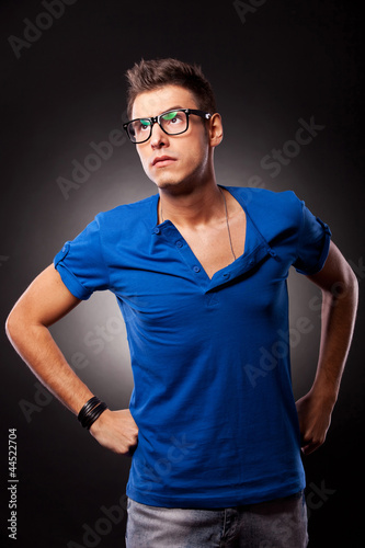 young casual man standing with hands on waist