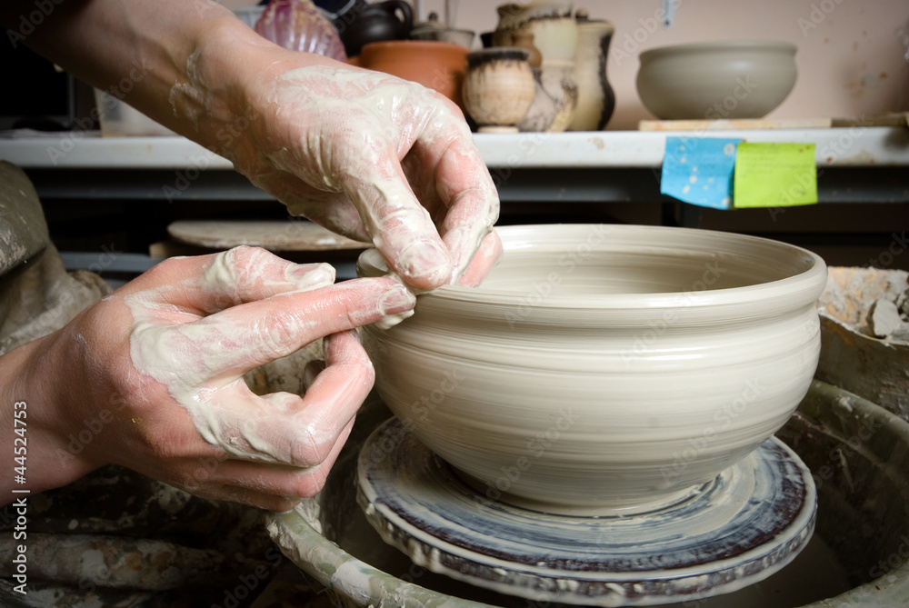 hands of a potter, creating an earthen jar on the circle