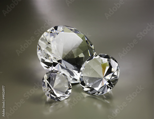 Drei gro  e Diamanten auf grauem Hintergrund mit Spiegelung