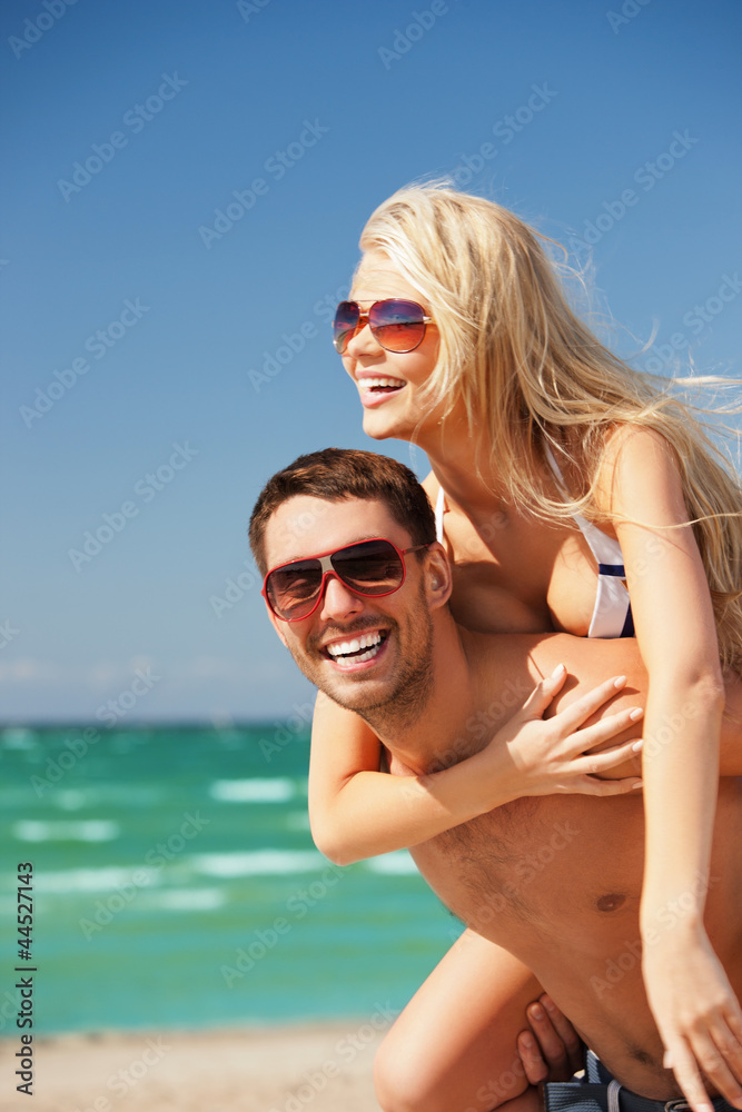 happy couple in sunglasses on the beach