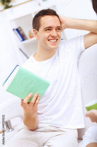 Young man at home with a book